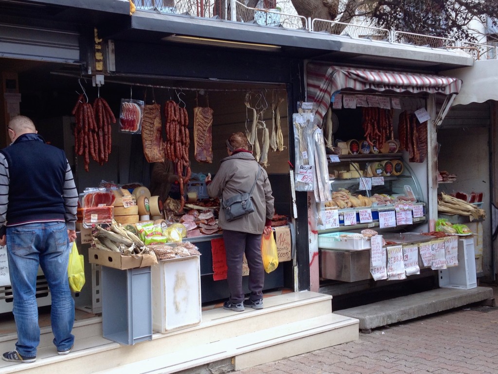 A meat and cheese vendor at the market. Check out the dried hanging cod in the booth!